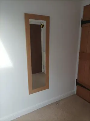 a mirror on a white wall in a room at Olde Farm Holiday Cottages in Banham