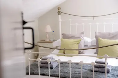 a bedroom with a white bed with yellow pillows at The Golden Key in Snape