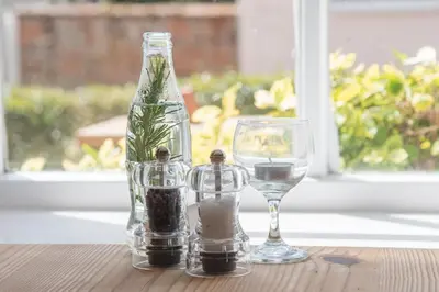two wine glasses and a bottle on a table at The Golden Key in Snape