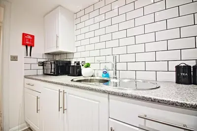 a kitchen with a sink and a white tiled wall at Star Apartment Ipswich, A Hidden Gem near the Waterfront in Ipswich