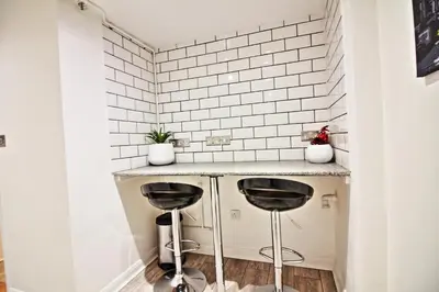 a kitchen with two stools under a counter at Star Apartment Ipswich, A Hidden Gem near the Waterfront in Ipswich