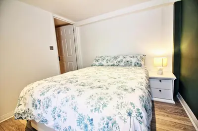a bedroom with a bed with a floral bedspread at Star Apartment Ipswich, A Hidden Gem near the Waterfront in Ipswich
