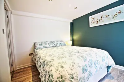 a bedroom with a bed and a green wall at Star Apartment Ipswich, A Hidden Gem near the Waterfront in Ipswich