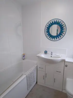 a white bathroom with a sink and a mirror at Brick Kiln Apartment in Campsea Ashe