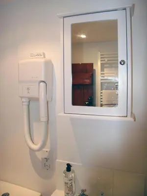 a bathroom with a soap dispenser above a sink at Brick Kiln Apartment in Campsea Ashe