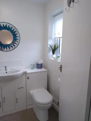 a bathroom with a toilet and a sink and a mirror at Brick Kiln Apartment in Campsea Ashe