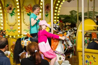 a young girl and a woman riding a carousel at Southend Central Hotel - Close to Beach, City Centre, Train Station & Southend Airport in Southend-on-Sea