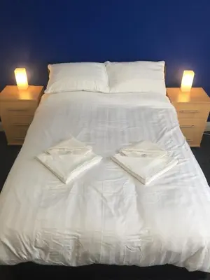 a white bed with two towels on top of it at Southend Central Hotel - Close to Beach, City Centre, Train Station & Southend Airport in Southend-on-Sea