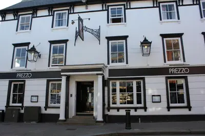 a white building with an american flag on it at The George Hotel Stansted Airport in Bishops Stortford