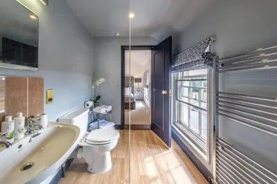 a bathroom with a toilet and a tub and a sink at The Black Lion, Long Melford in Long Melford