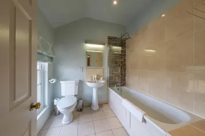 a bathroom with a toilet and a sink and a tub at The Black Lion, Long Melford in Long Melford