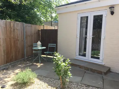 a patio with a table and chairs next to a fence at The Annexe at Asbit Lodge in Mildenhall