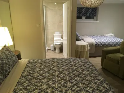 a hotel room with two beds and a couch and a bedroom at The Annexe at Asbit Lodge in Mildenhall