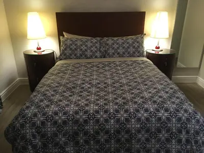 a bedroom with a large bed with two lamps at The Annexe at Asbit Lodge in Mildenhall