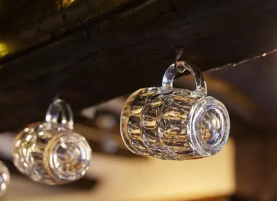 a group of silver bells hanging from a ceiling at Bull Hotel by Greene King Inns in Long Melford