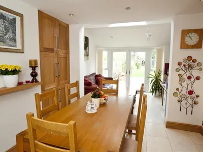 a kitchen and dining room with a wooden table and chairs at Rosa's Bed and Breakfast in Cambridge