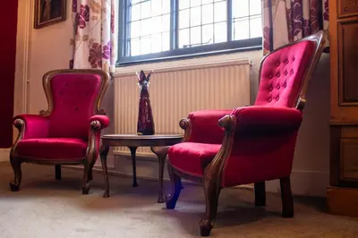 a room with two chairs and a table and a window at The Scole Hotel in Scole