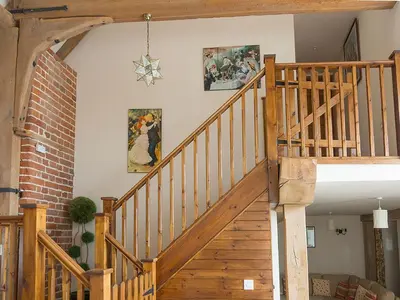 a wooden staircase in a house with paintings on the wall at Old Corn Mill - Ukc3170 in Walpole