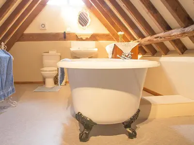 a bathroom with a large white tub in a attic at Old Corn Mill - Ukc3170 in Walpole