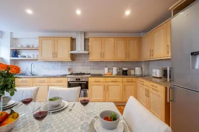 a kitchen with a table with glasses of wine at 67 Pebble Cottage in Aldeburgh