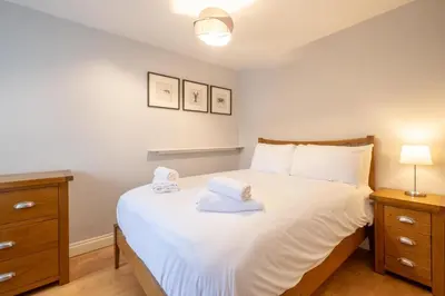 a bedroom with a bed with two towels on it at 67 Pebble Cottage in Aldeburgh
