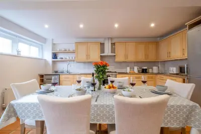 a dining room with a table and chairs and a kitchen at 67 Pebble Cottage in Aldeburgh