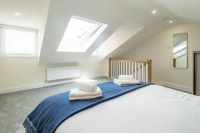 a bedroom with a large bed with towels on it at Avocet Cottage in Aldeburgh