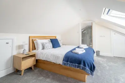 a bedroom with a bed with a blue blanket at Avocet Cottage in Aldeburgh