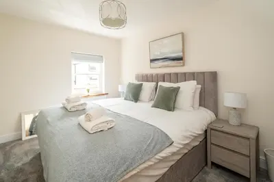 a bedroom with a large bed with towels on it at Avocet Cottage in Aldeburgh