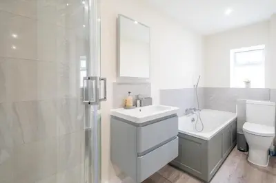 a bathroom with a sink and a toilet and a shower at Avocet Cottage in Aldeburgh
