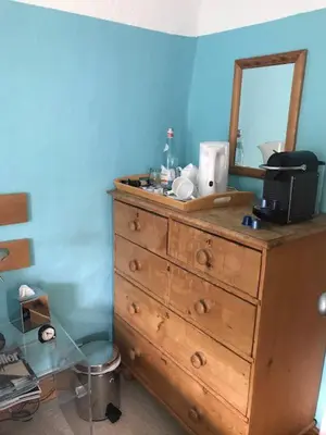 a wooden dresser with a mirror on top of it at The White House in Bishops Stortford