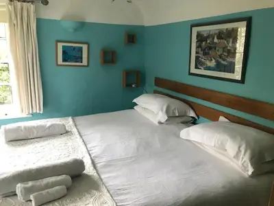 two beds in a bedroom with blue walls at The White House in Bishops Stortford