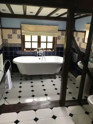 a bathroom with a bath tub and a window at The White House in Bishops Stortford