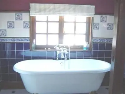 a white bath tub in a bathroom with a window at The White House in Bishops Stortford
