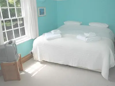 a bedroom with a white bed and a window at The White House in Bishops Stortford