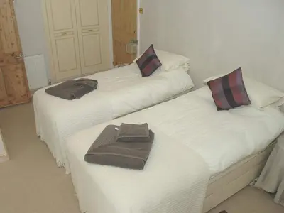 two beds with towels on them in a room at The White House in Bishops Stortford
