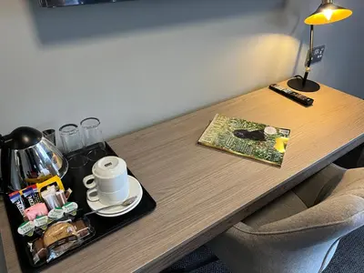 a wooden table with a coffee pot and a plate on it at The Essex Golf & Country Club Hotel in Coggeshall