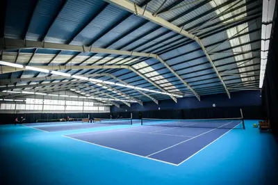 a tennis court inside of a building at The Essex Golf & Country Club Hotel in Coggeshall