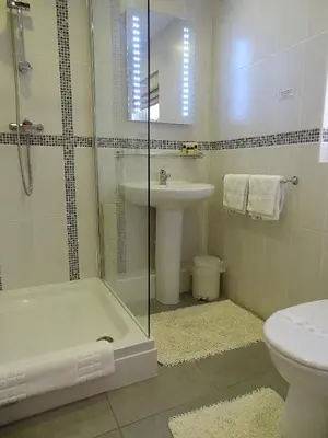 a bathroom with a sink and a tub and a toilet at The Chudleigh in Clacton-on-Sea
