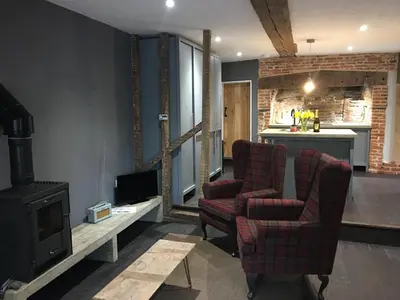 a living room with two chairs and a stove at Square House Bildeston High street in Ipswich