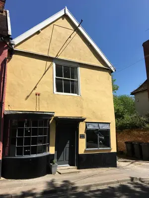 a yellow building with a large window at Square House Bildeston High street in Ipswich
