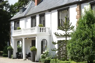 a white house with a white balcony at Satis House Hotel in Yoxford