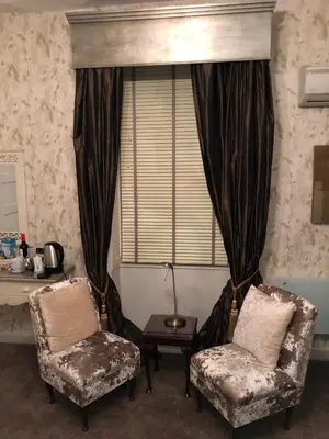 a living room with two chairs and a window at Satis House Hotel in Yoxford
