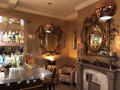 a bar with a fireplace and a mirror at Satis House Hotel in Yoxford