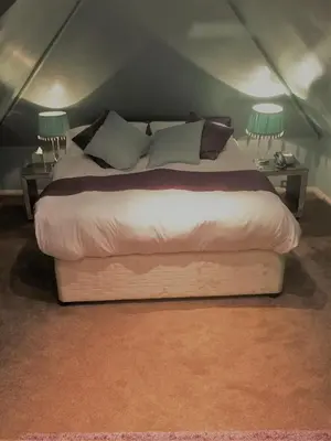 a large bed in a room with two lamps at Satis House Hotel in Yoxford