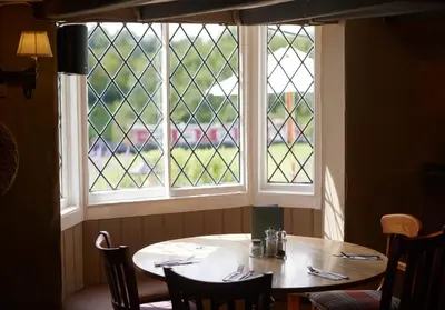 a table in a room with a window at Old Ferry Boat by Greene King Inns in St Ives