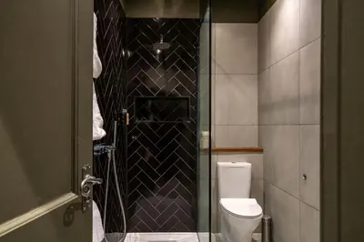 a bathroom with a toilet and a glass shower at The Bull Inn in Mildenhall