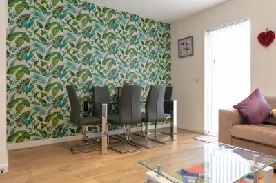 a dining room with chairs and a wall with a wallpaper at Modern & Exquisite Trumpington Townhouse with Parking & 5 mins to Papworth hospital in Cambridge