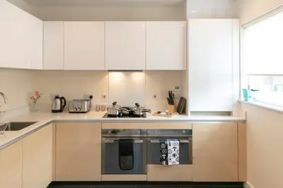 a kitchen with white cabinets and an oven at Modern & Exquisite Trumpington Townhouse with Parking & 5 mins to Papworth hospital in Cambridge