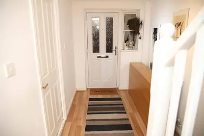 a hallway with a white door and a striped rug at Stay 69G - Hush View House, Romford, London Havering in Romford